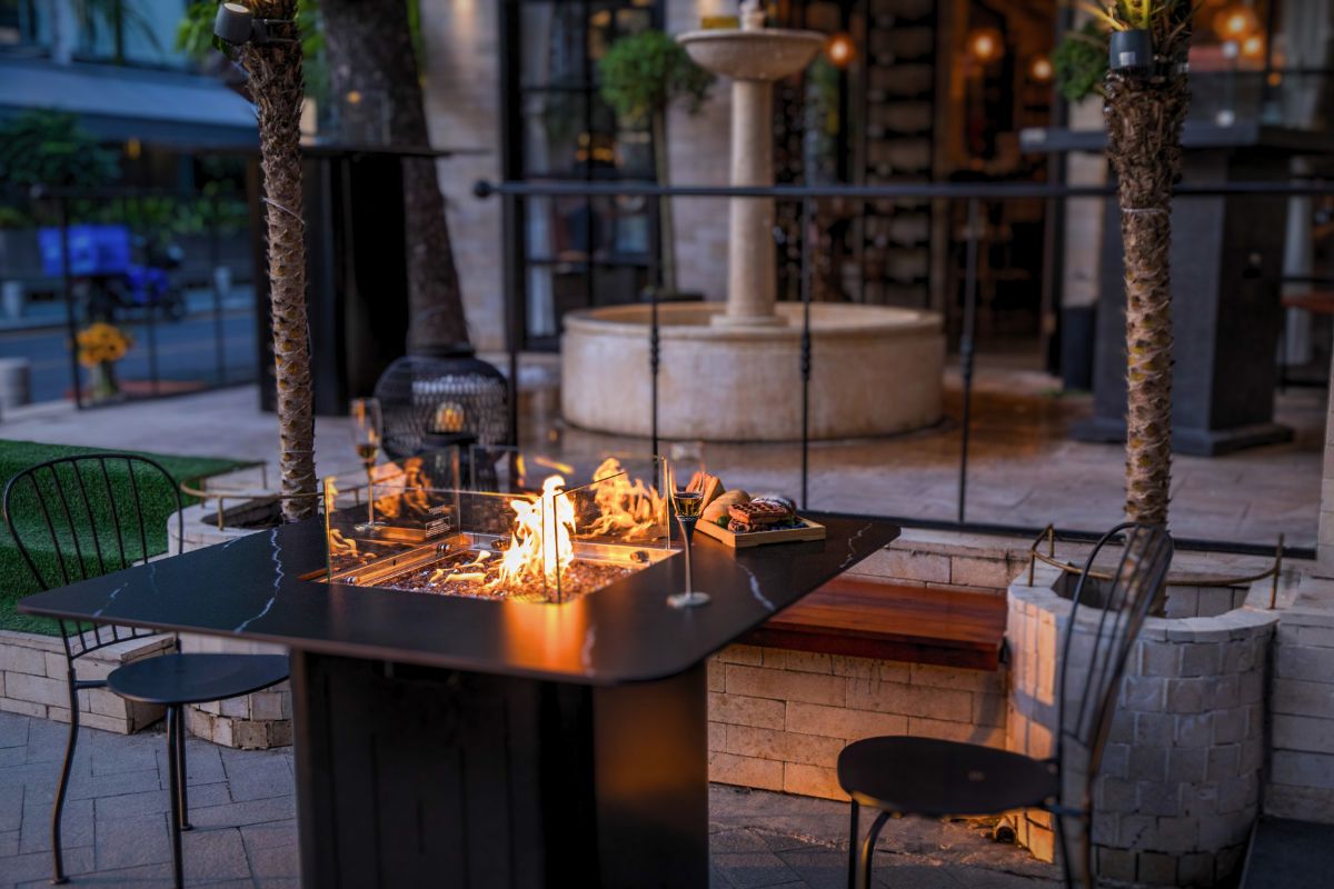 Stůl BRUGGE s hořícím ohněm na terase restaurace